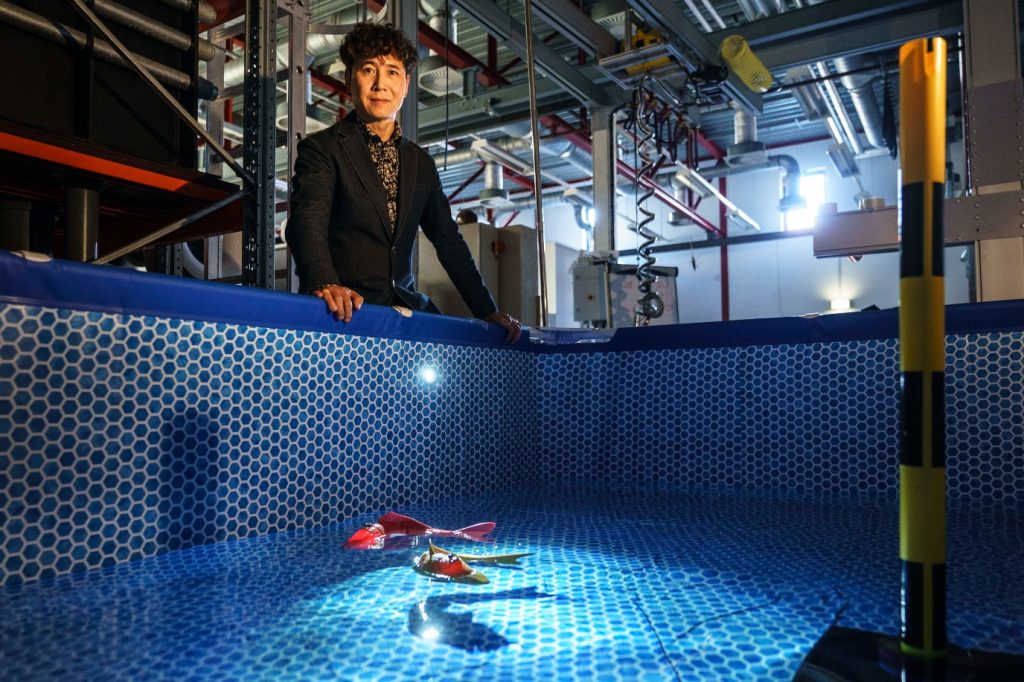 Ming Cao bij een bad met robotvissen